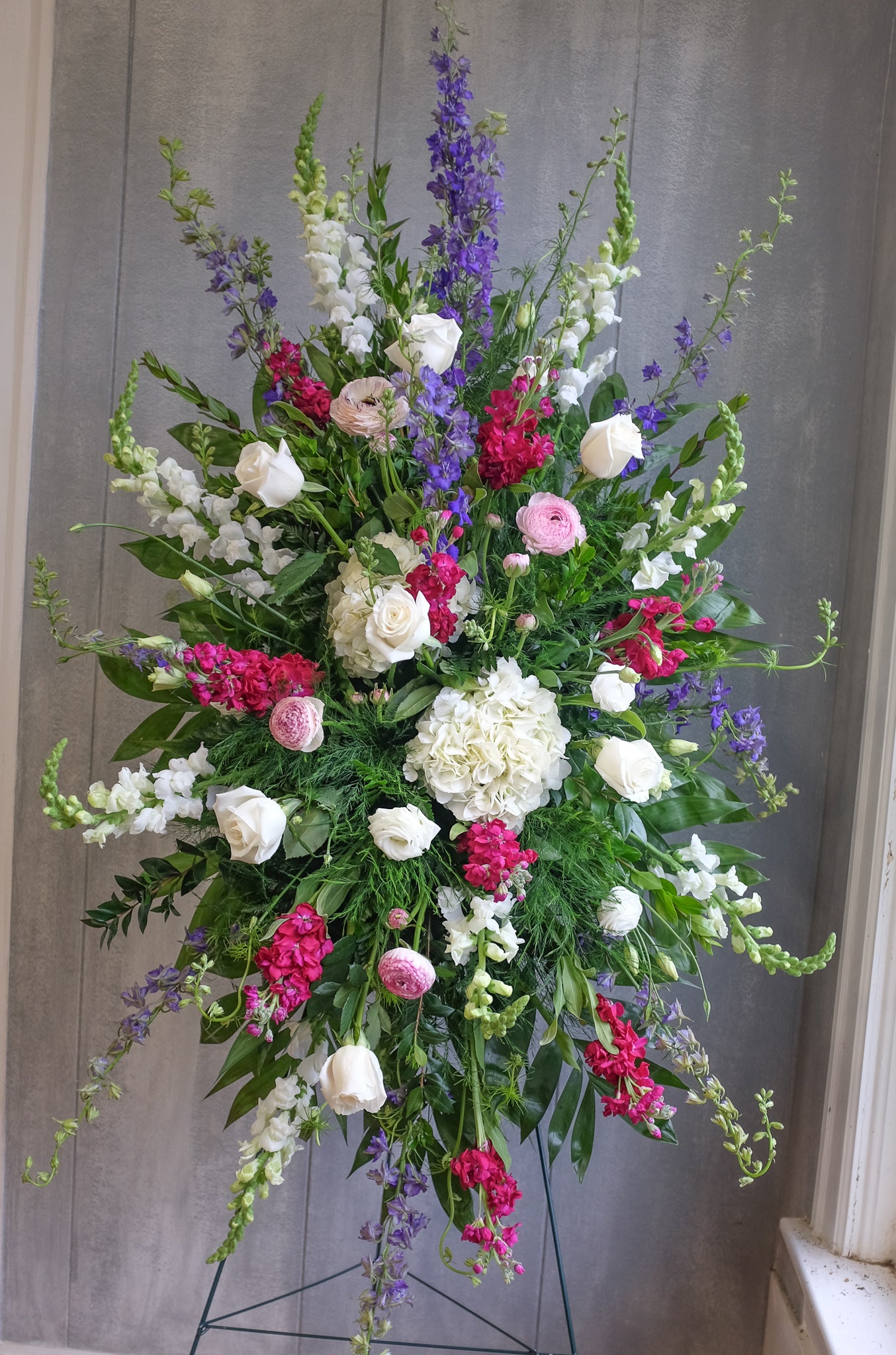 standing easel spray with hydrangea, ranunculus, larkspur, and stock by Michler's