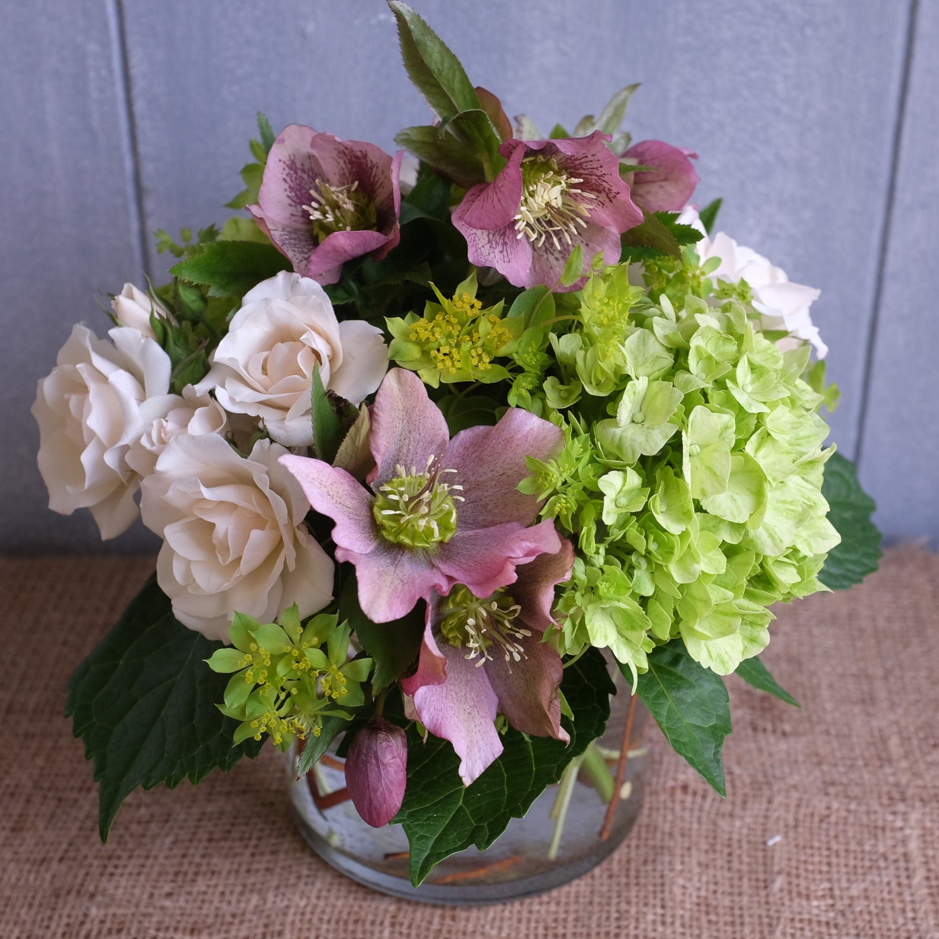 Lush flower arrangement featuring hellebores blooms.