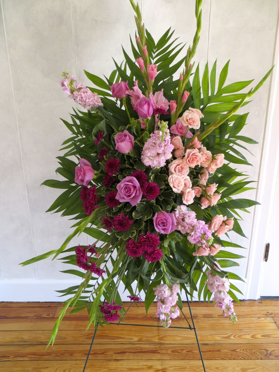 Easel spray with a gradient from pink flowers to purple. Designed by Michler's Florist in Lexington, KY
