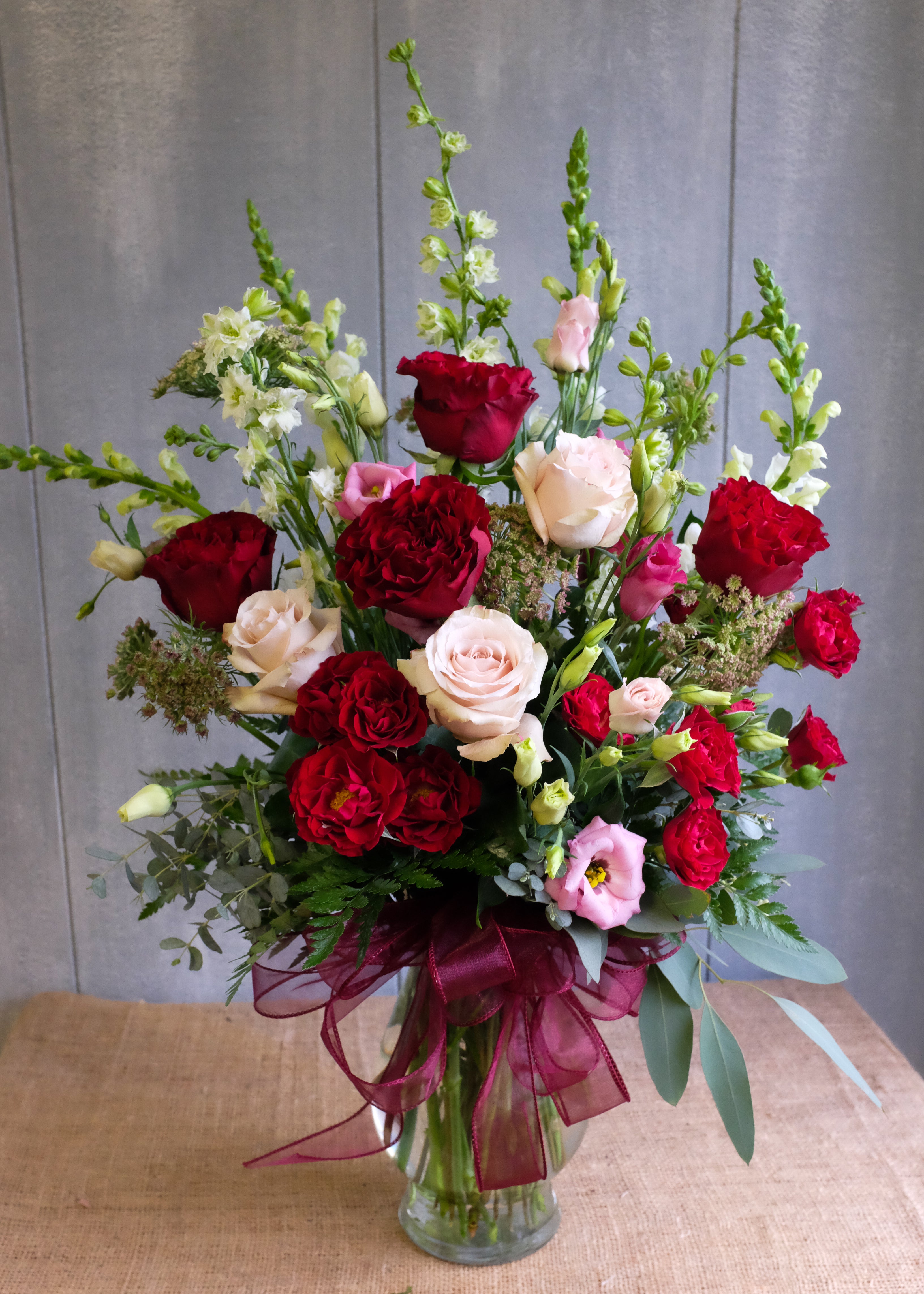Virginia flower bouquet with red roses, pink lisianthus, and white snap dragons. Designed by Michler's Florist in