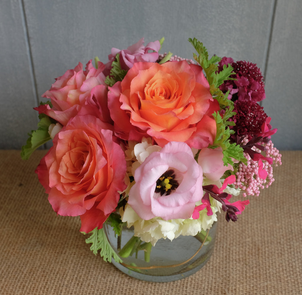 Lush bouquet of flowers in orange pink and raspberry.