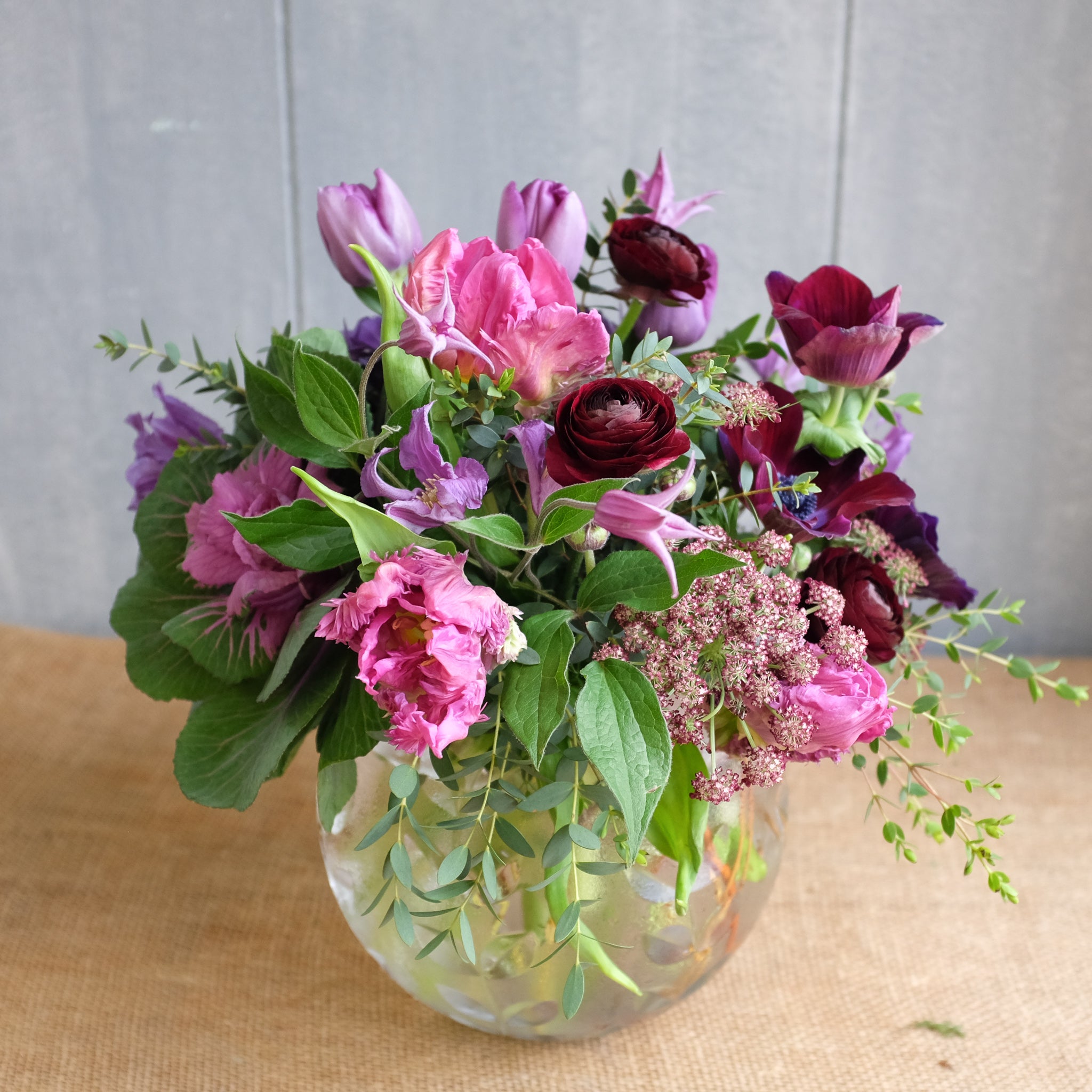 Bubble bowl arrangement with purple flowers by Michler's Florist