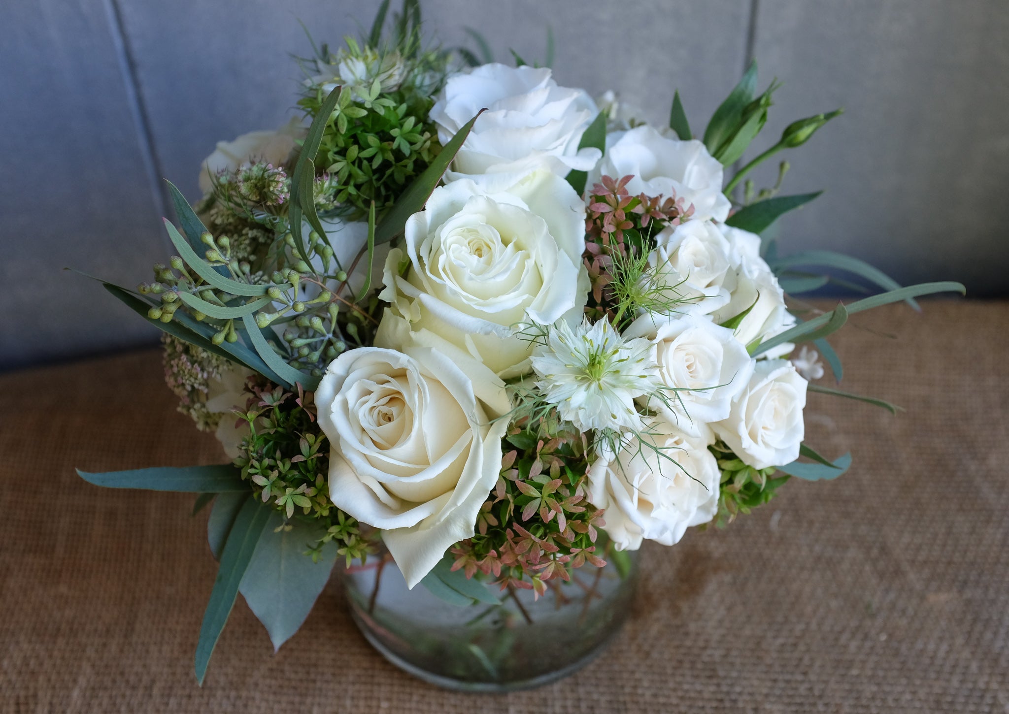 contemporary floral bouquet with white roses, hydrangea, lisianthus and autumnal seasonal accents