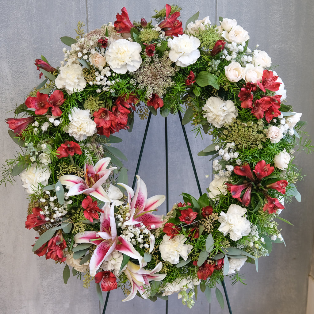 floral sympathy wreath with stargazer lilies, carnations, roses, Queen Anne's lace, and baby's breath by Michler's Florist in Lexington, KY