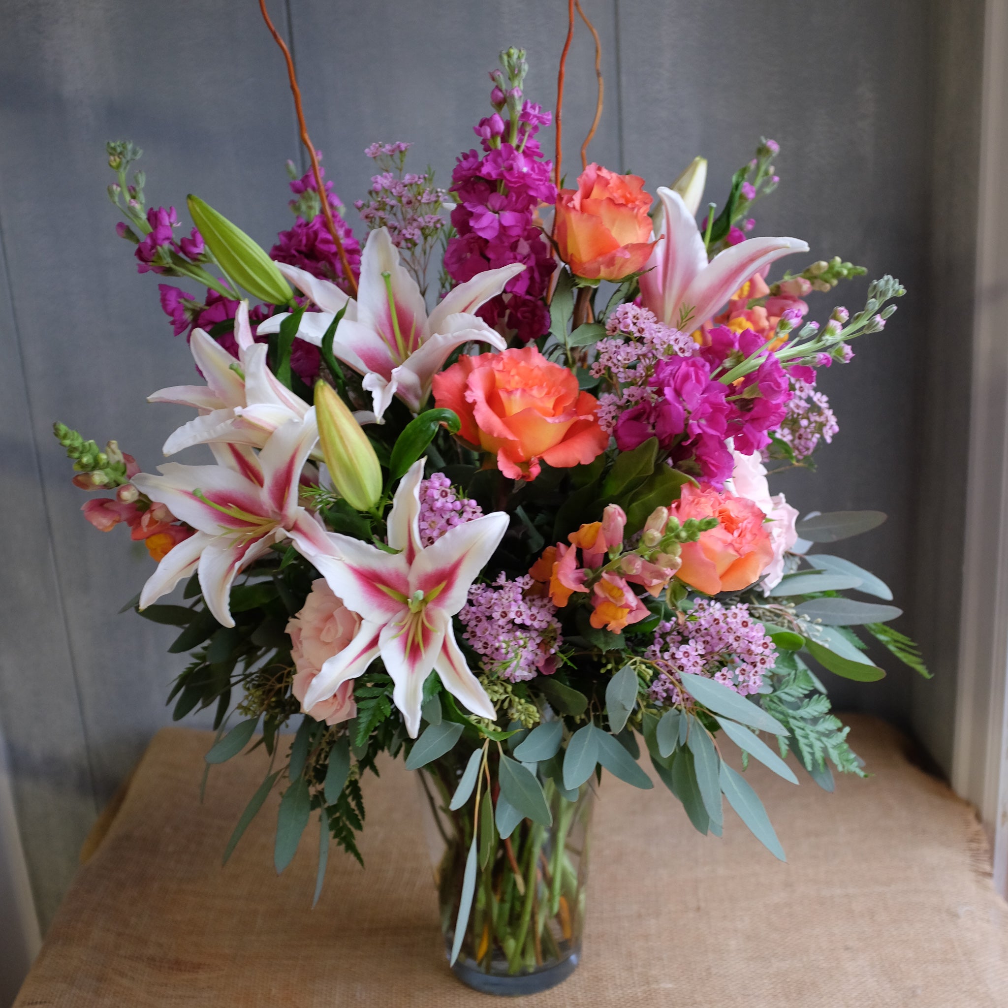 Large bouquet brimming with warm and vibrant flowers.
