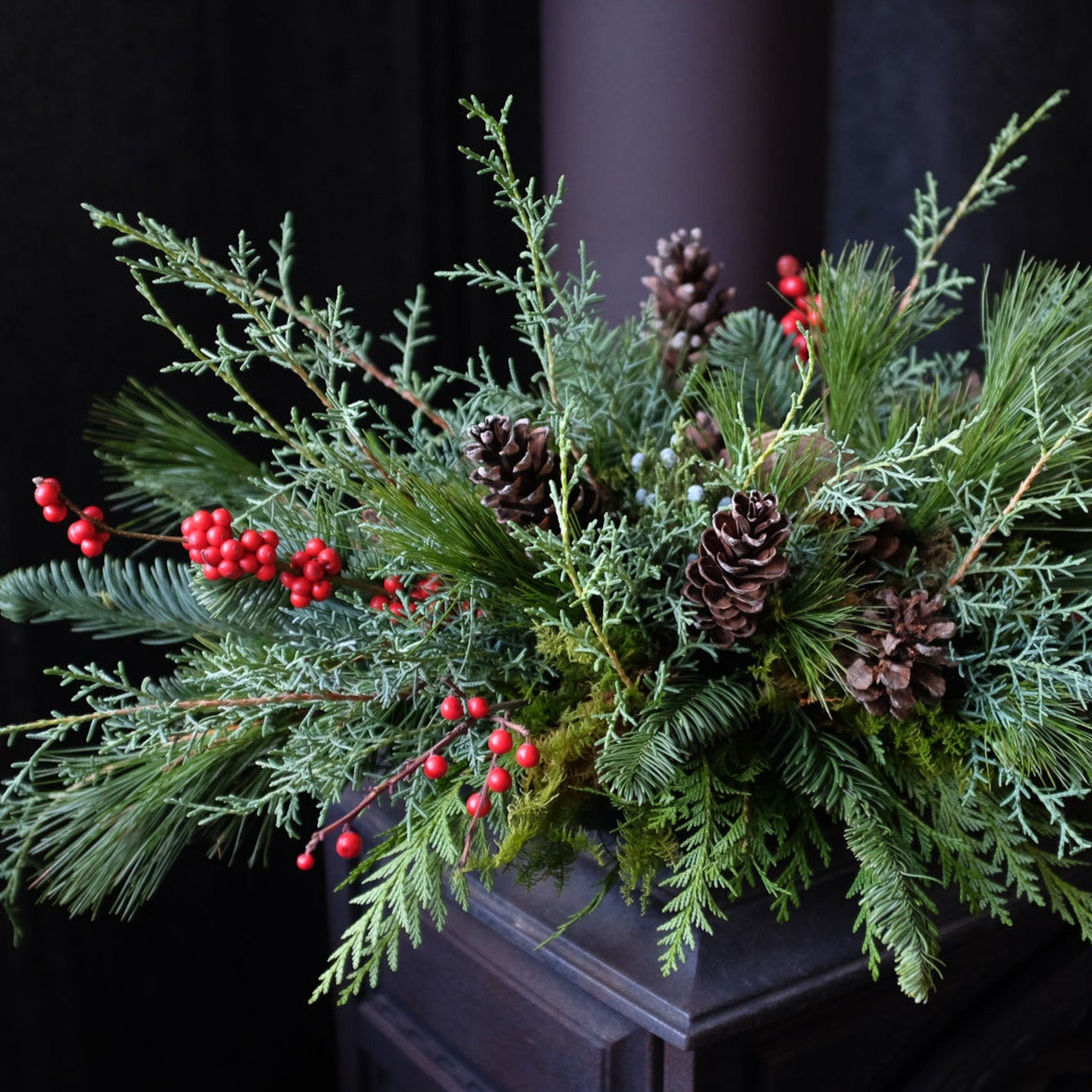 Woodland Centerpiece with moss, berries, pine cones and cedar.