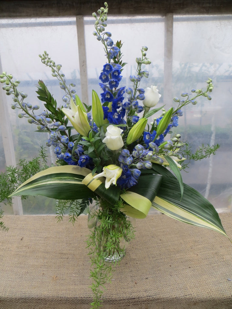Blue and White Flower Arrangement: White Roses, Blue Delphium designed in a glass vase by Michler's Florist in Lexington, KY