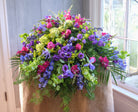 floral casket spray with hydrangea, ranunculus, delphinium, and green accents by Michler's