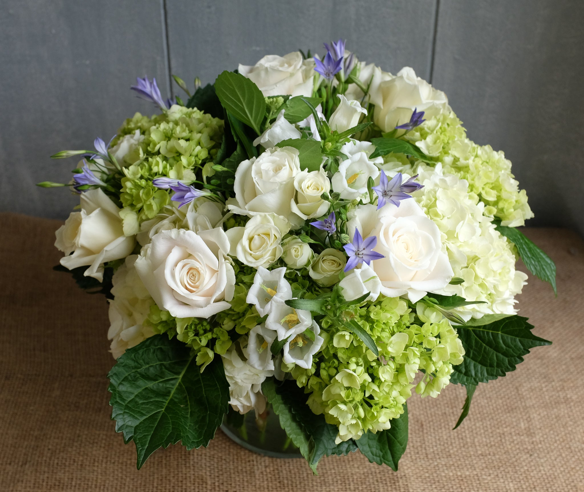 Lush floral bouquet of white and green flowers with a touch of blue