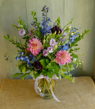 Floral arrangement with cool toned flowers of blue, purple, and pink