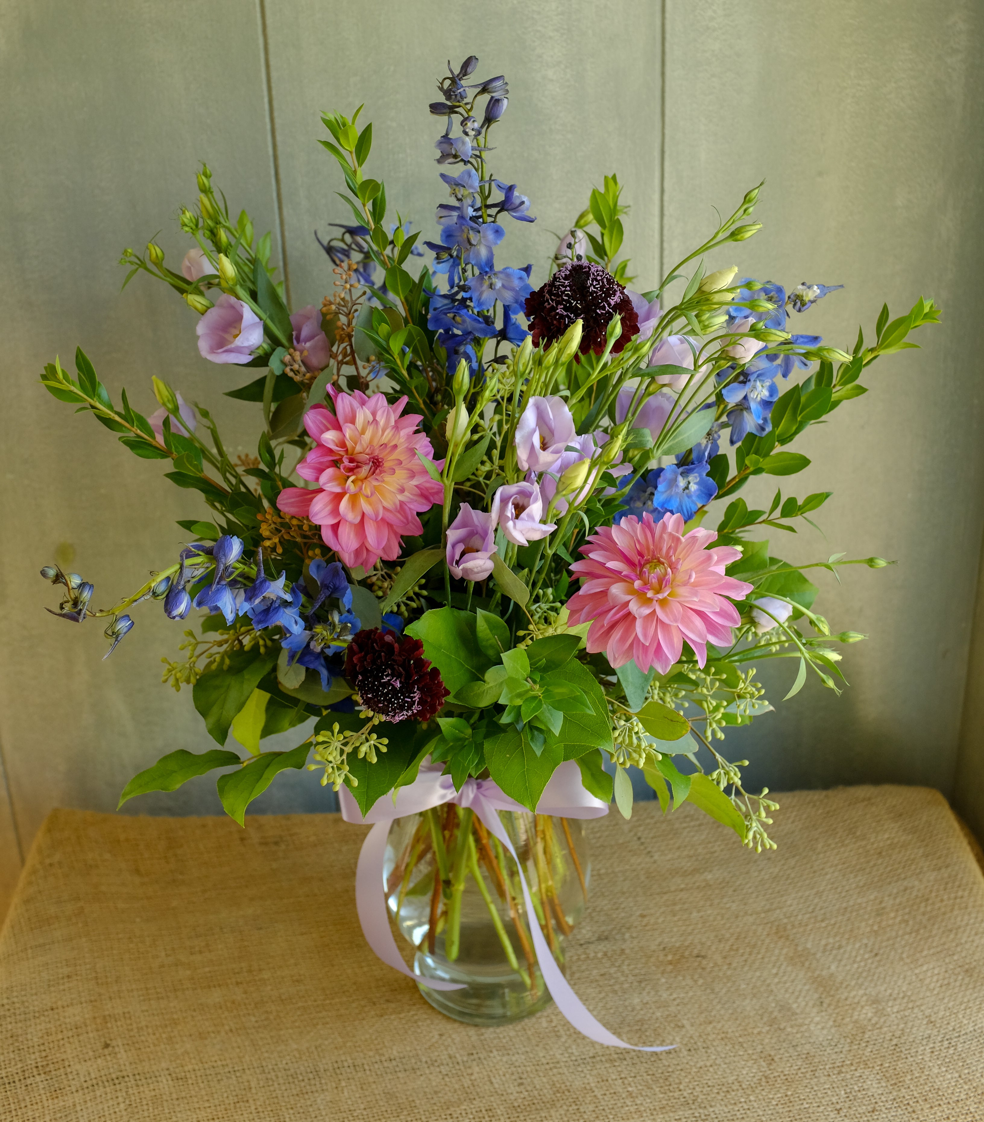 Floral arrangement with cool toned flowers of blue, purple, and pink