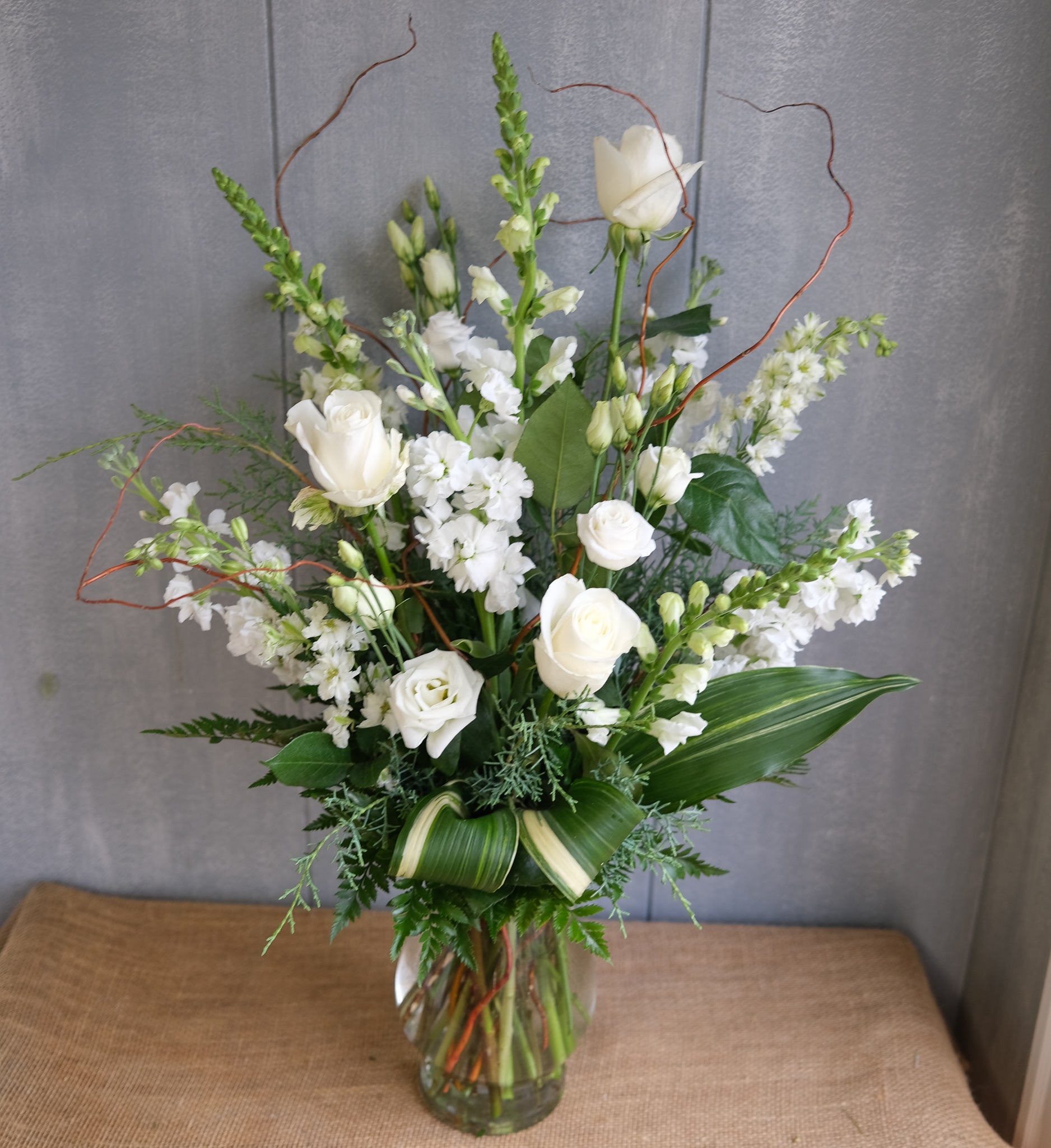 tall and elegant flower arrangement with roses, lisianthus, and stock with natural accents by Michler's Florist in Lexington, KY