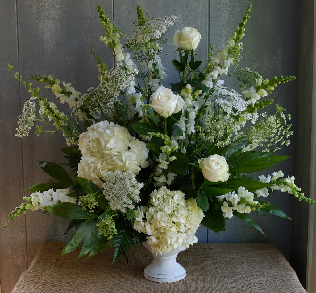 Floral arrangment with white hydrangea, white roses, white snapdragon by Michler's Floris