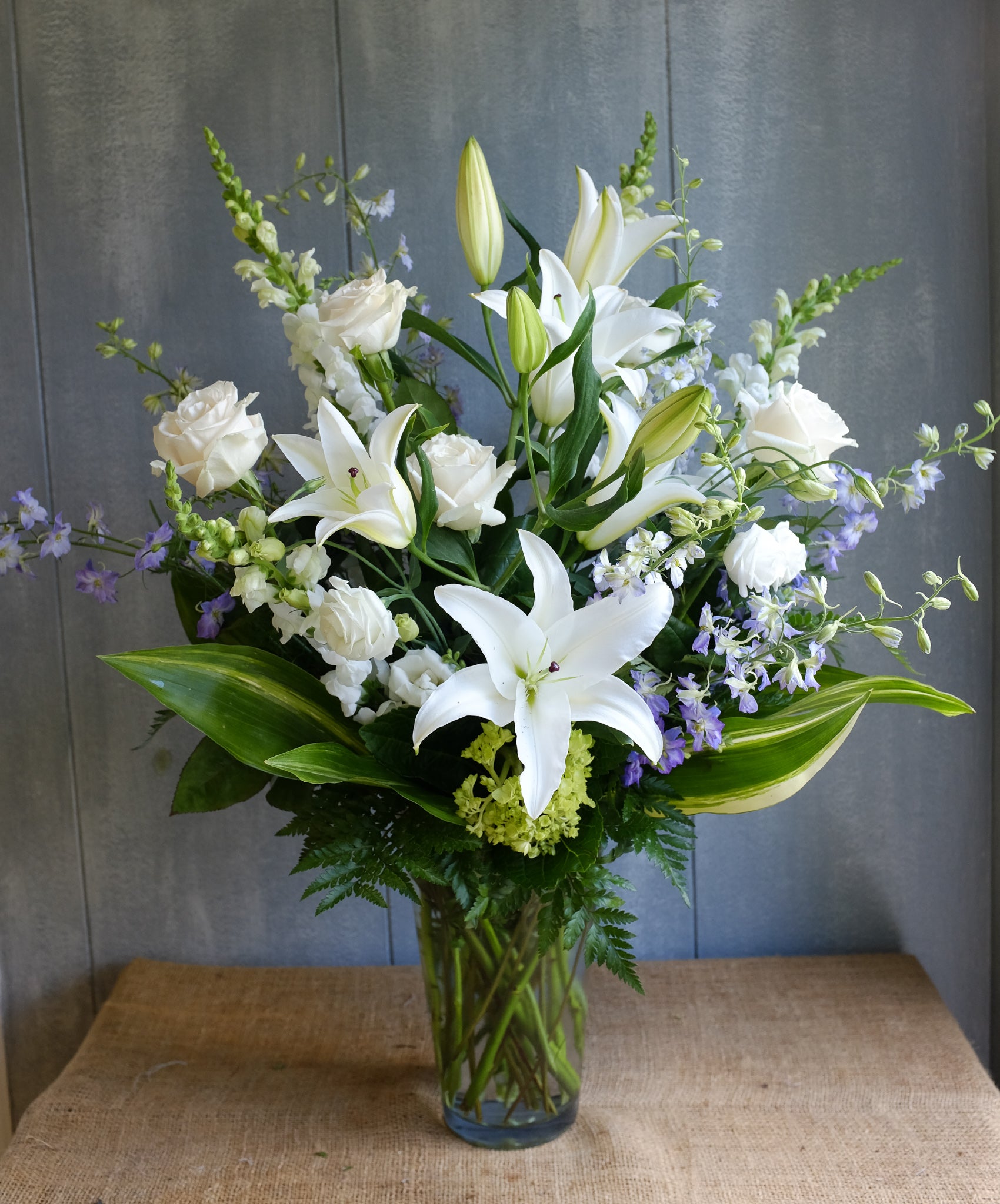 Floral Arrangement by Michler's Florist with lilies, delphinium, hydrangea, white roses
