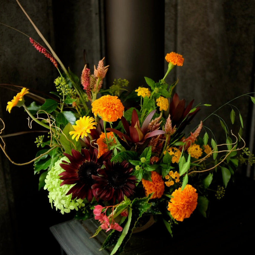 Prestige Floral Designed in an Urn in Autumn tones of Yellow, Orange and Burgundy Flowers.  Designed by Michlers in Lexington, KY