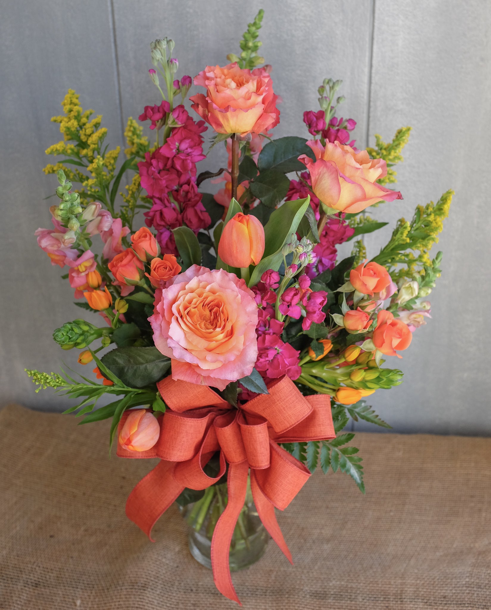 tall and elegant flower arrangement with roses, pink delphinium, and stock by Michler's