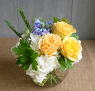 Flower bouquet with white hydrangea, yellow roses, and blue accent.