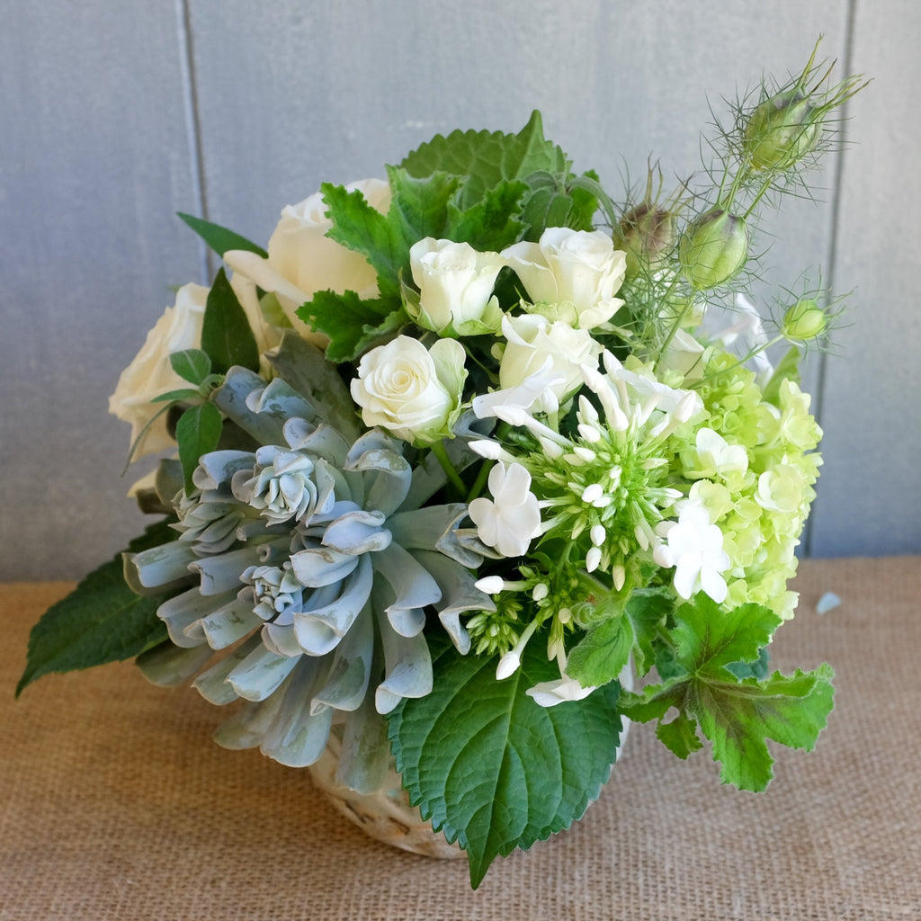 Lush floral bouquet of white and green flowers with a touch of blue