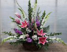 Eldemere Funeral Basket with White Snap Dragons, Stargazer Lilies, and Purple Stock. Designed by Michler's Florist in Lexington, KY
