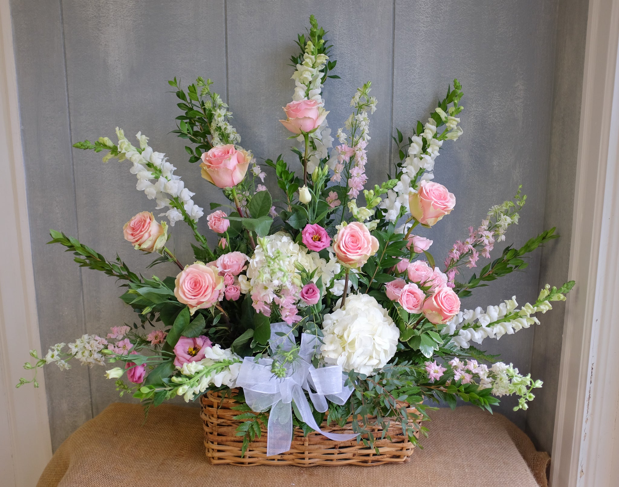 Pink and white funeral basket by Michler's Florist.