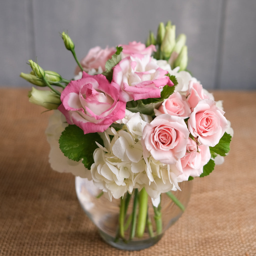 low and lush flower arrangement with roses, ranunculus, and hydrangea by Michler's