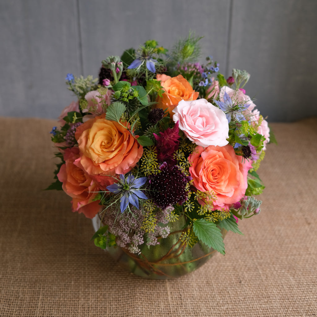 A compact arrangement of various flowers and colors.