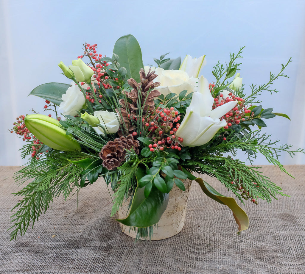 Hanover: Woodland Flower Arrangement in a birch pot with white lilies, pepperberries, pinecones, and evergreens. Designed by Michler's Florist in Lexington, KY