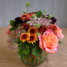 low and lush flower arrangement with roses, mums, and Queen Anne's lace by Michler's
