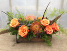 High on Rose: Thanksgiving Centerpiece with Pheasant feathers, orange Pincushion Protea, and orange Roses | Michler's Florist 