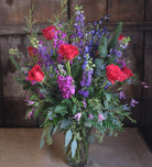 a tall and elegant floral design with roses, delphinium, and seeded eucalyptus by Michler's