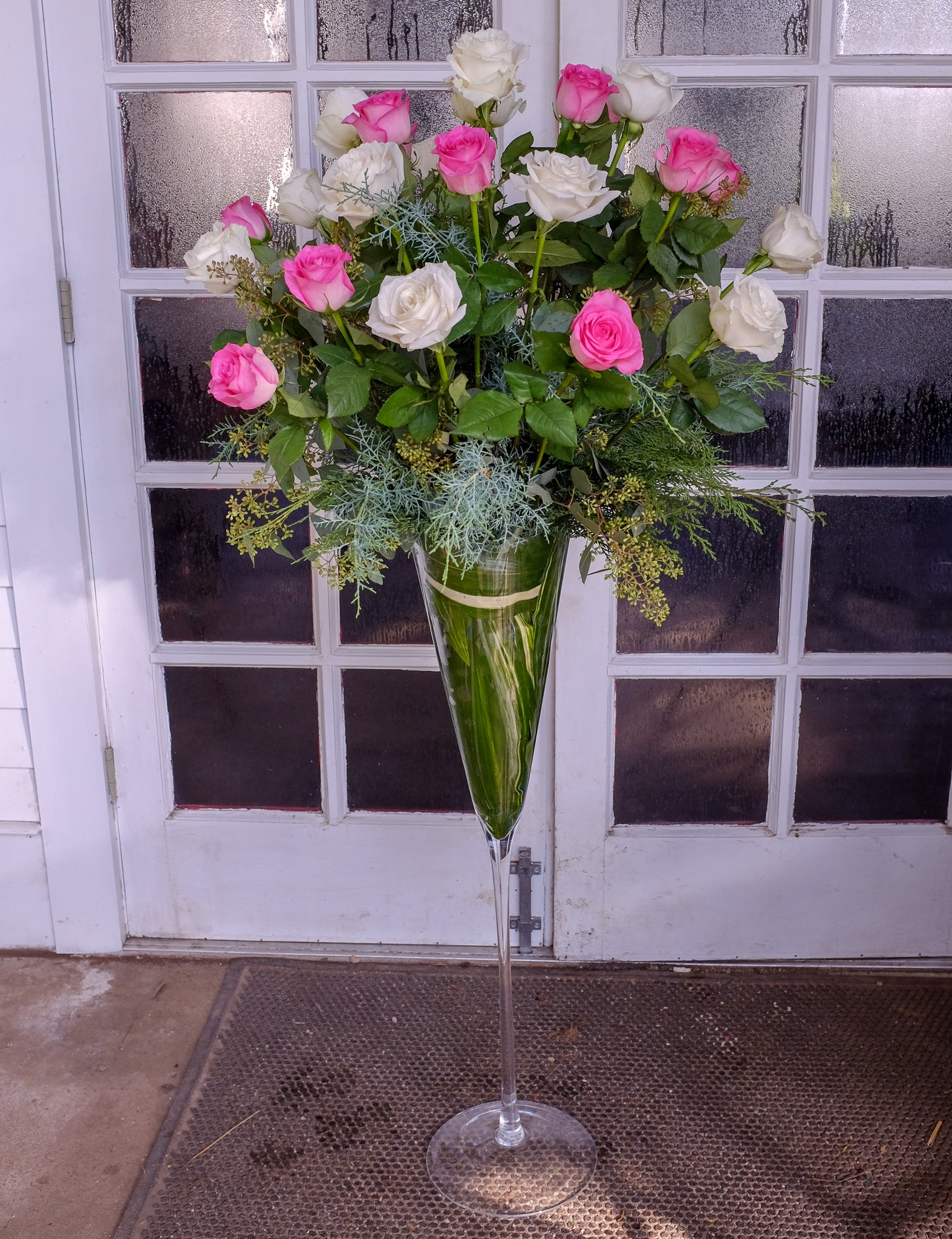 Tall glass vase with pink and white roses by Michler's Florist