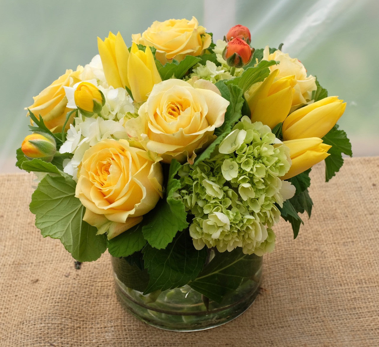 Madris Flower Arrangement with yellow roses, tulips, ranunculus and hydrangea. Designed by Michler's Florist in Lexington, KY