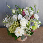 low and lush floral arrangement with hydrangea, Queen Anne's lace, blue thistle, and white roses by Michler's