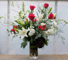 Large vase arrangement with red roses, lilies, branches, and matthiola. Designed by Michler's Florist in Lexington, KY