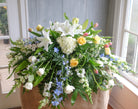 floral casket spray with roses, lilies, hydrangea, tulips, larkspur, and stock by Michler's Florist in Lexington, KY