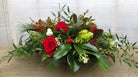 Preston: Christmas Centerpiece with Magnolia, Red Roses and Italian Ruskus. Designed by Michler's Florist in Lexington, KY