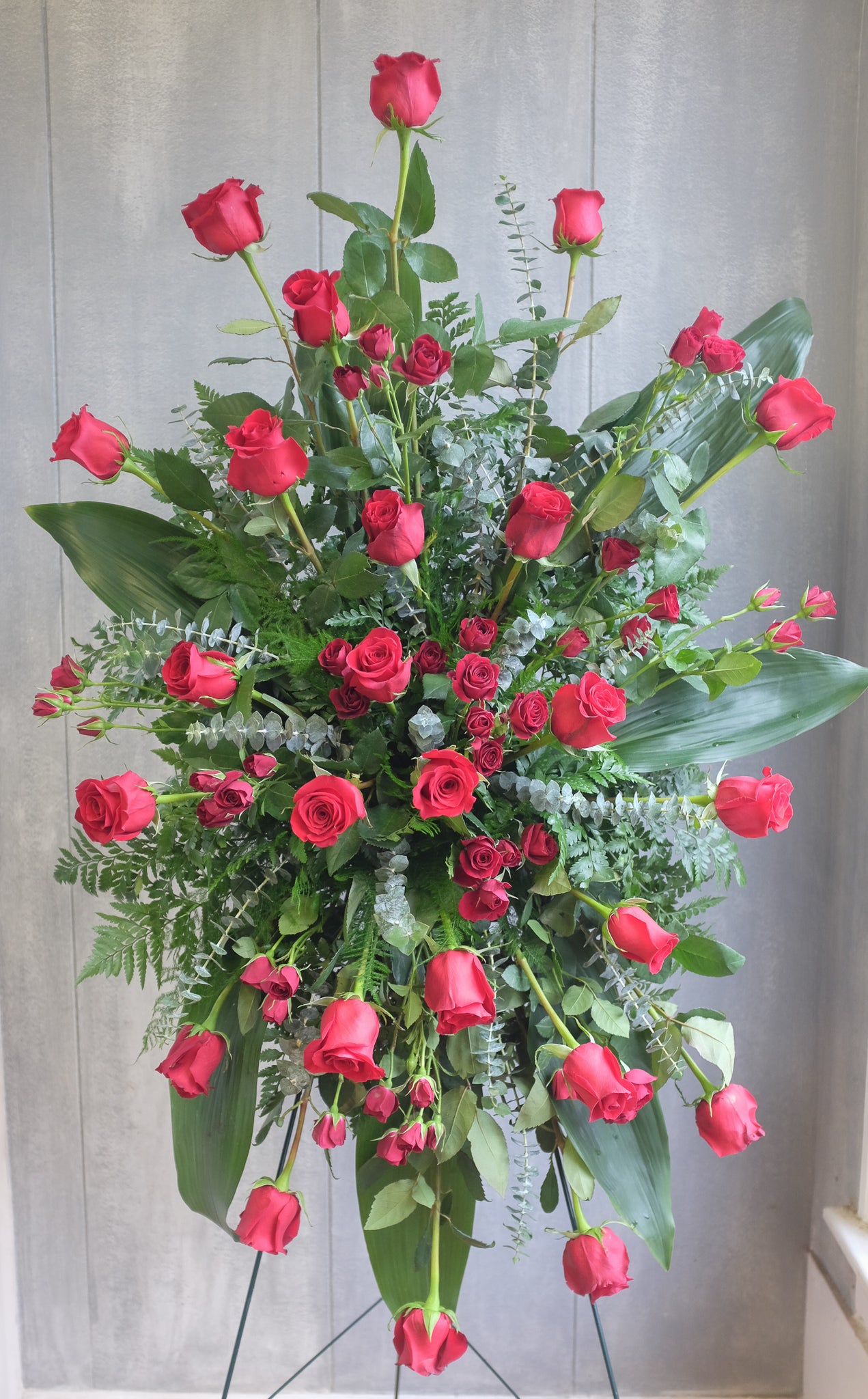 floral easel spray with red roses, eucalyptus, and greenery by Michler's