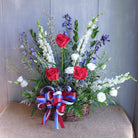 floral sympathy basker with red roses, white stock, and blue delphium by Michler's Florist in Lexington, KY