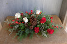 floral centerpiece with roses, berries, pinecones, and winter greens by Michler's