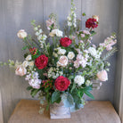 tall and elegant floral arrangement with roses, stock, and seeded eucalyptus by Michler's