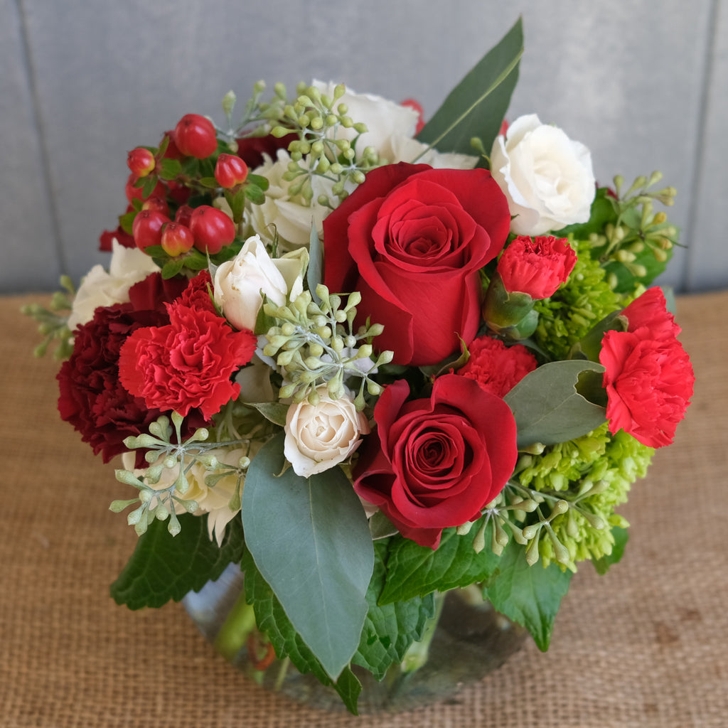 low and lush floral arrangement with roses, carnations, and seeded eucalyptus by Michler's Florist in Lexington, KY