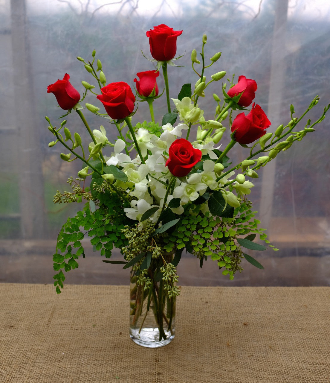 Red roses and white dendrobium orchids designed in a vase by Michler's Florist in Lexington, KY