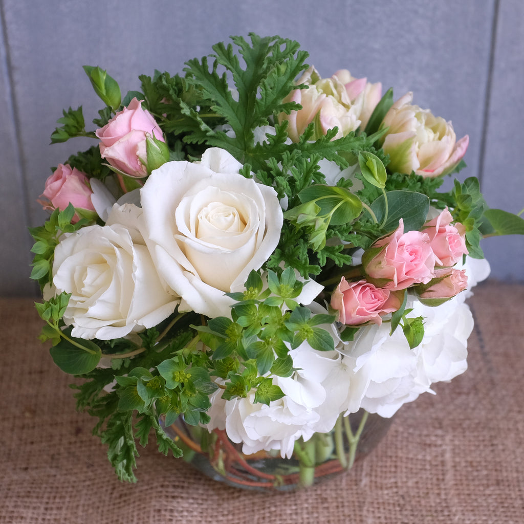 low and lush arrangement of roses, spray roses, and hydrangea by Michler's Florist in Lexington, KY