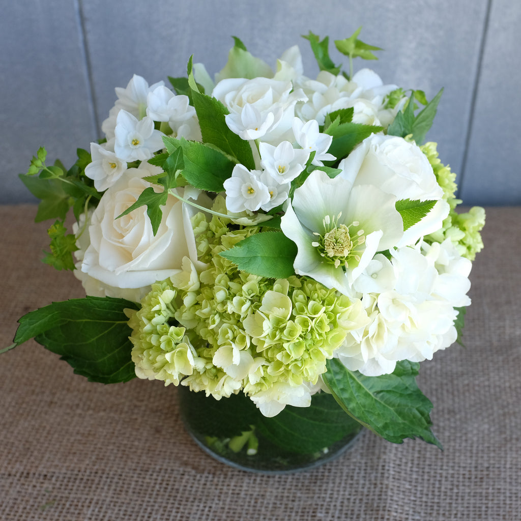 a low and lush flower arrangement with roses, hydrangea, and paperwhites by Michler's