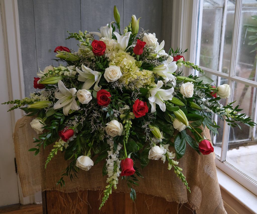 floral casket spray with roses, lilies, hydrangea, and stock by Michler's Florist in Lexington, KY