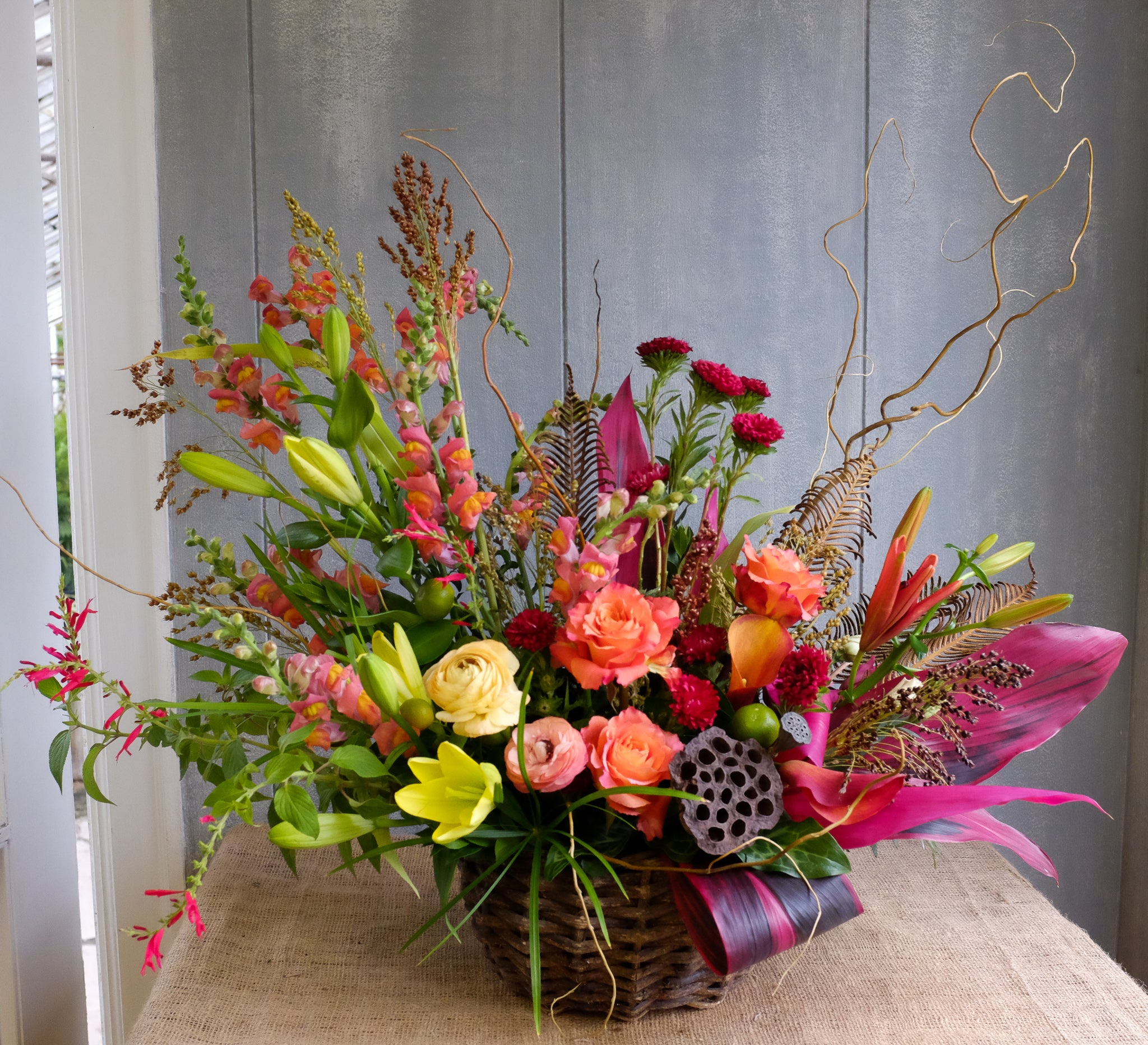Wicker basket flower design brimming with grasses and autumn toned flowers | Michler's Florist