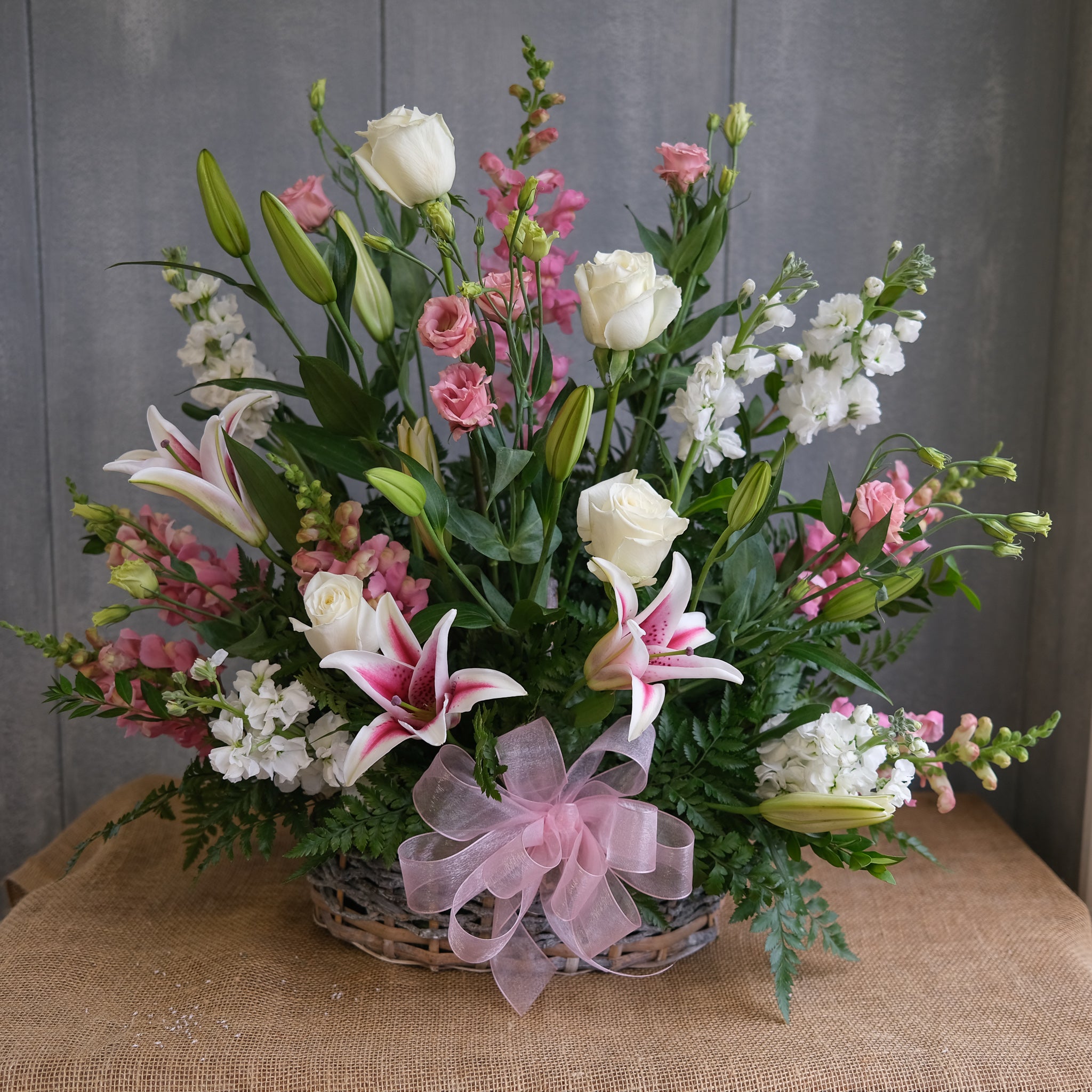 floral funeral basket with stargazer lilies, roses, lisianthus, and stock by Michler's Florist in Lexington, KY