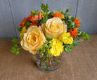 Bright floral bouquet with yellow roses and seasonal flowers in yellows and oranges