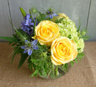 Flower arrangement with yellow roses and green hydrangea