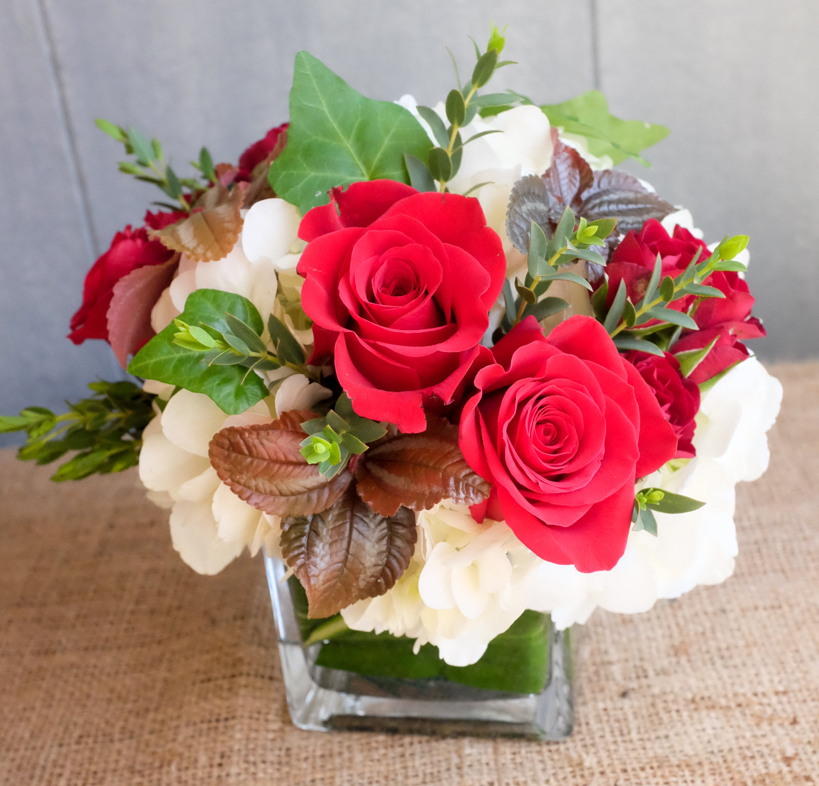 Sherbrooke: Floral design with white hydrangea and red roses, ivy in a square vase.  Designed by Michler's Florist in Lexington, KY